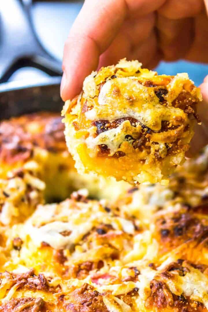 Keto Pizza Pull-Apart Rolls being pulled out of a cast iron skillet