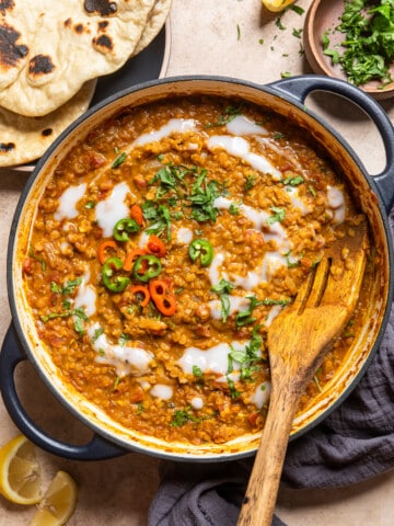 masoor dal in a skillet with fresh chilis and herbs.