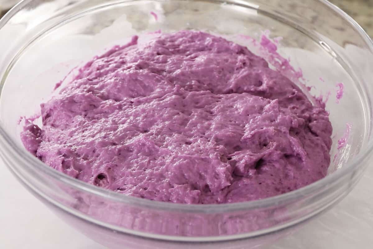 making fluffy ube brioche bread dough in large glass bowl