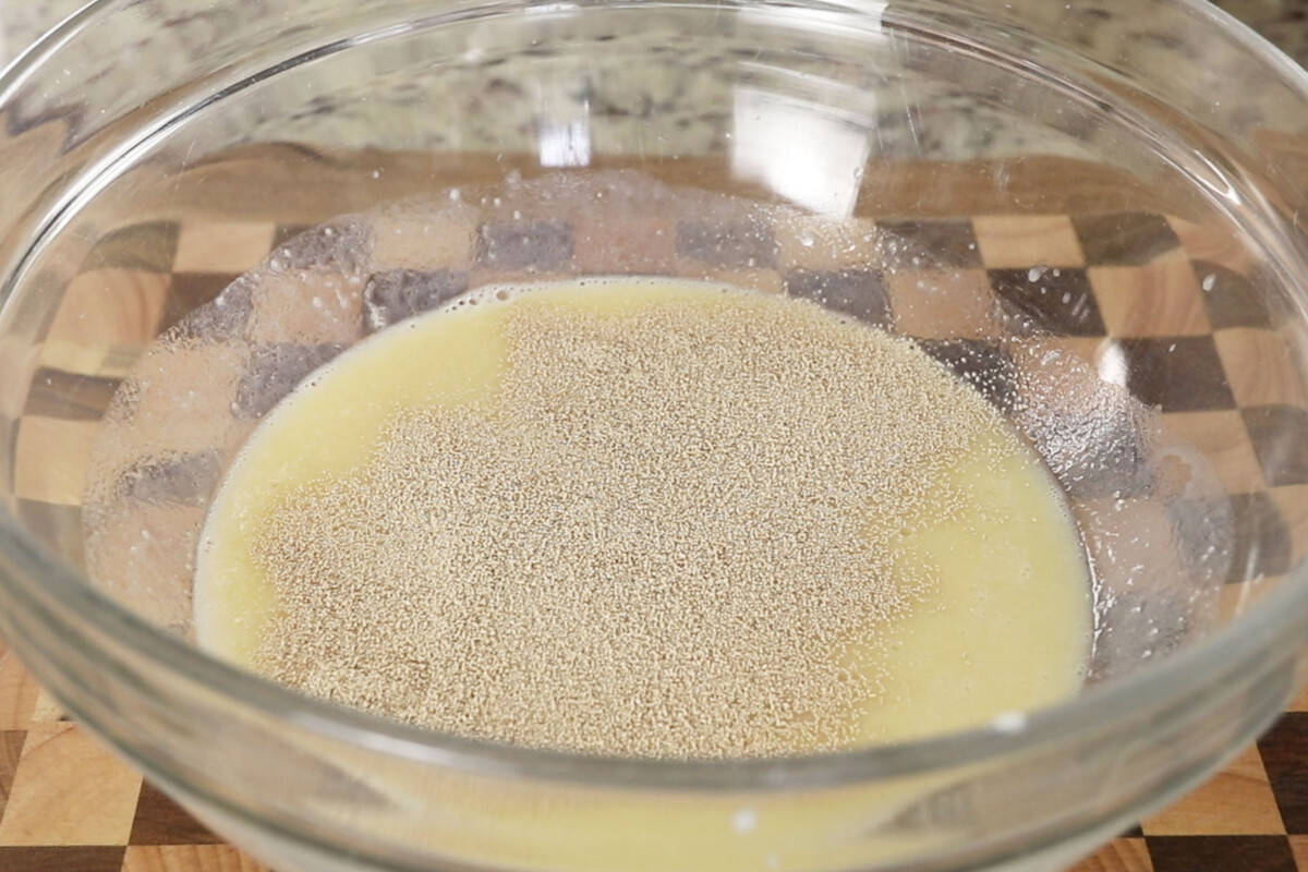 activating yeast for fluffy ube brioche bread dough in large glass bowl