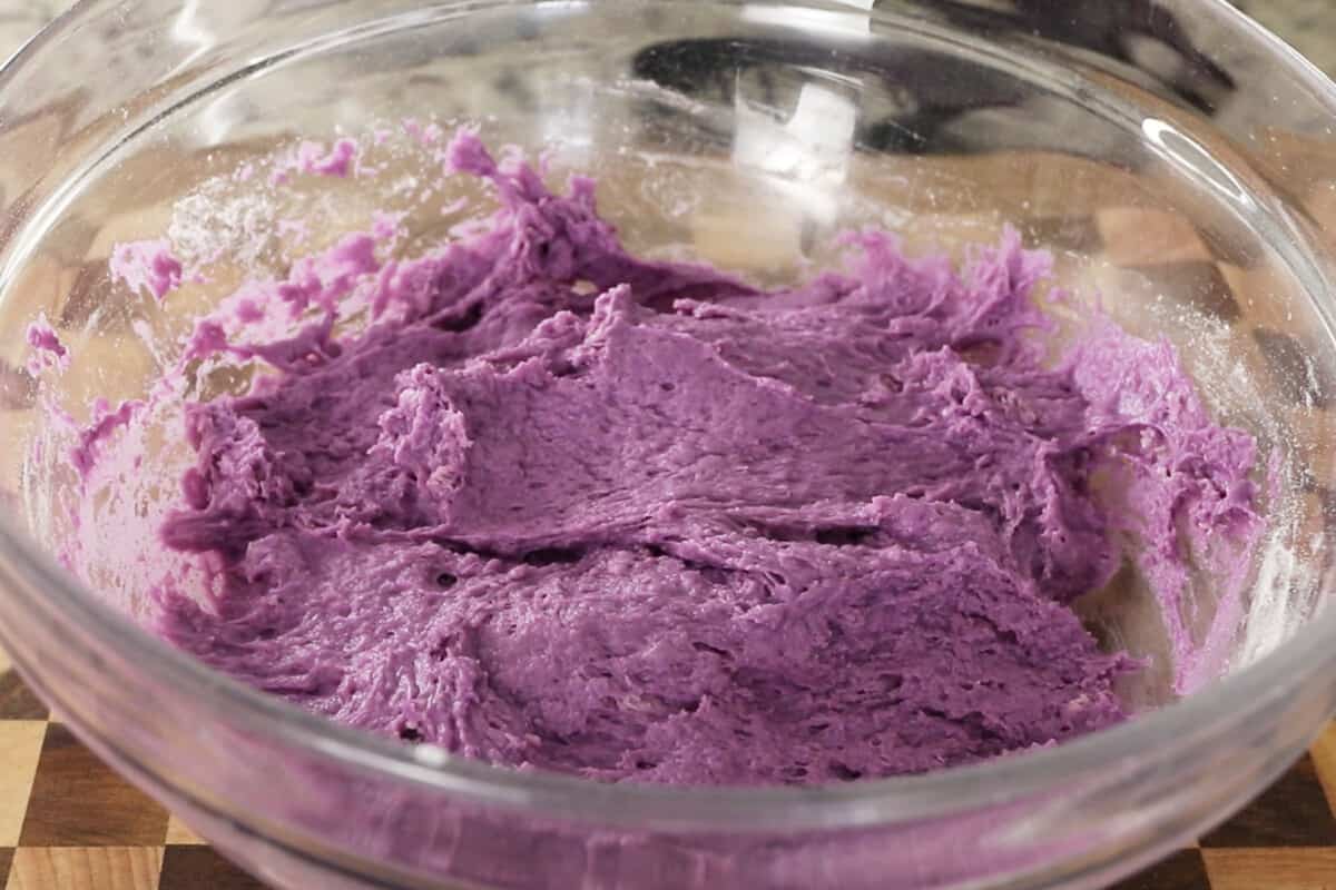 making fluffy ube brioche bread dough in large glass bowl