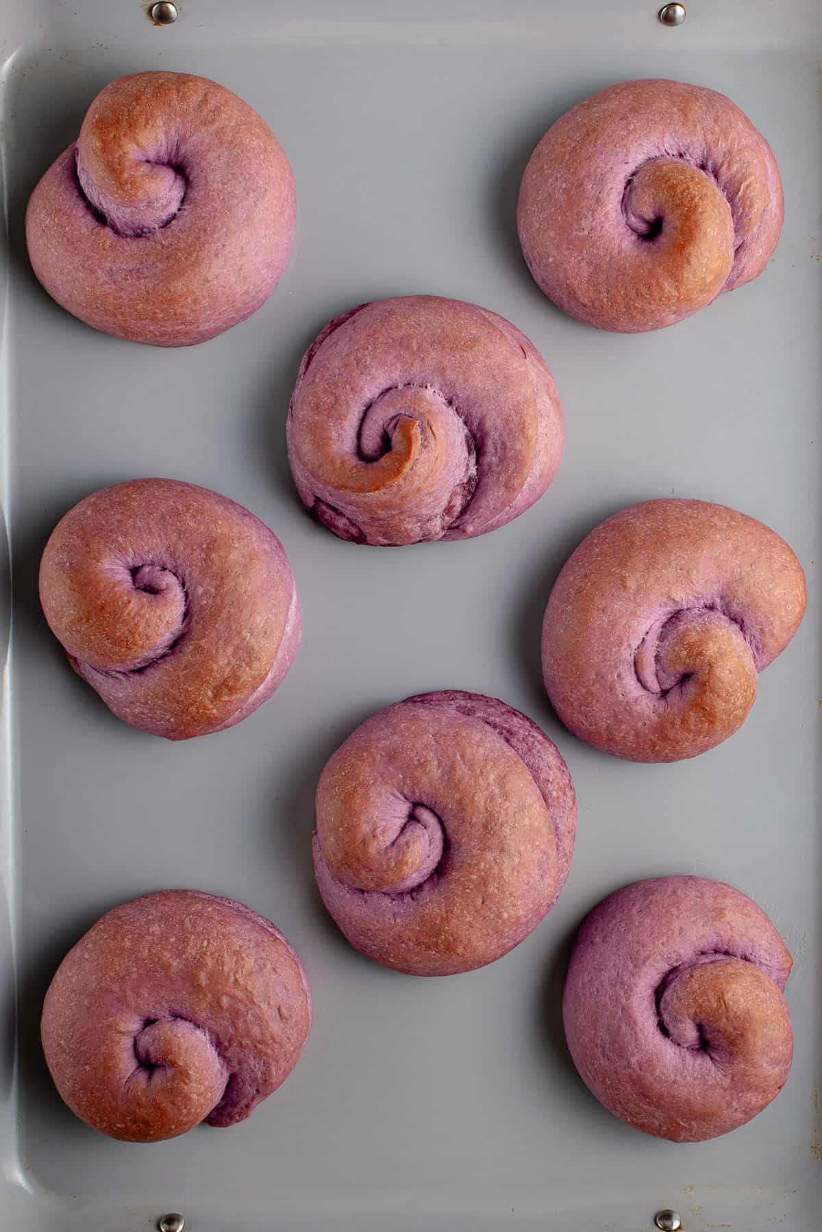 overhead photo of ube ensaymada dough on baking sheet after baking