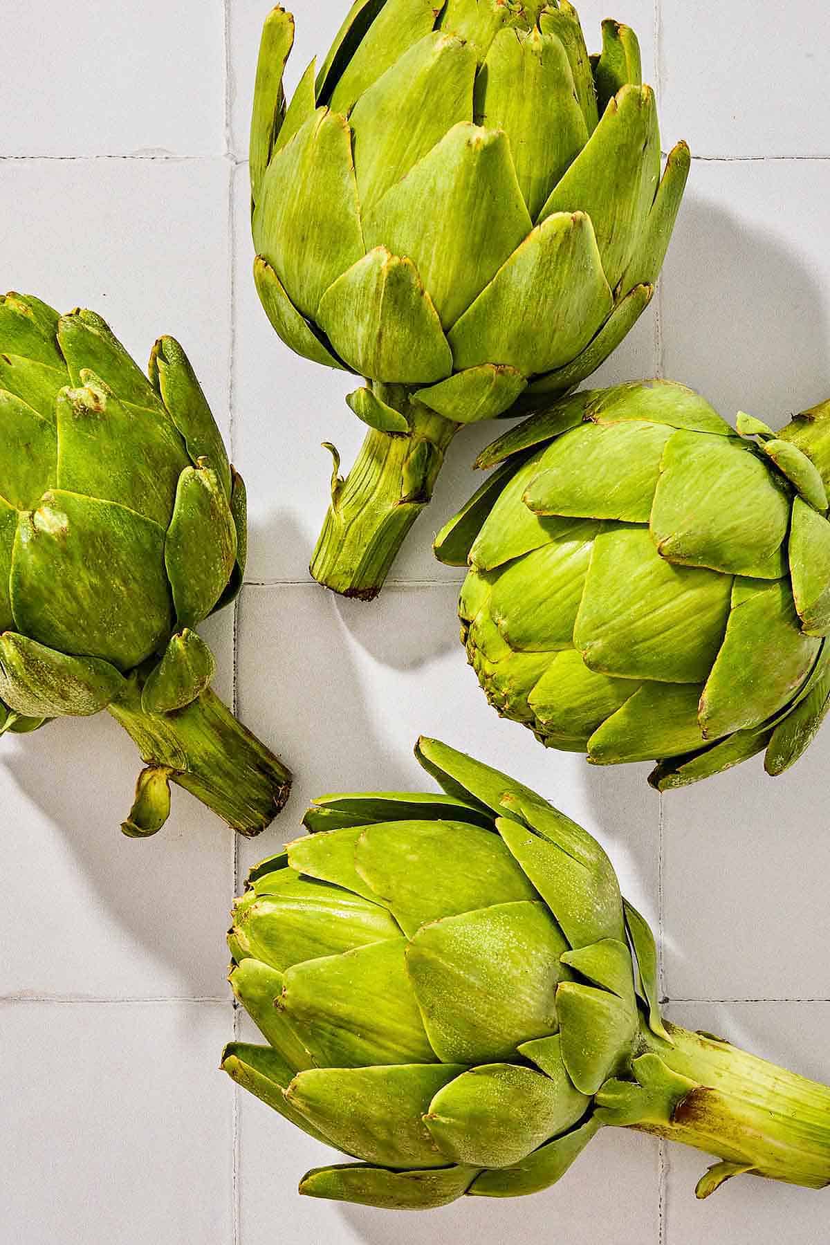 An overhead photo of 4 globe artichokes.