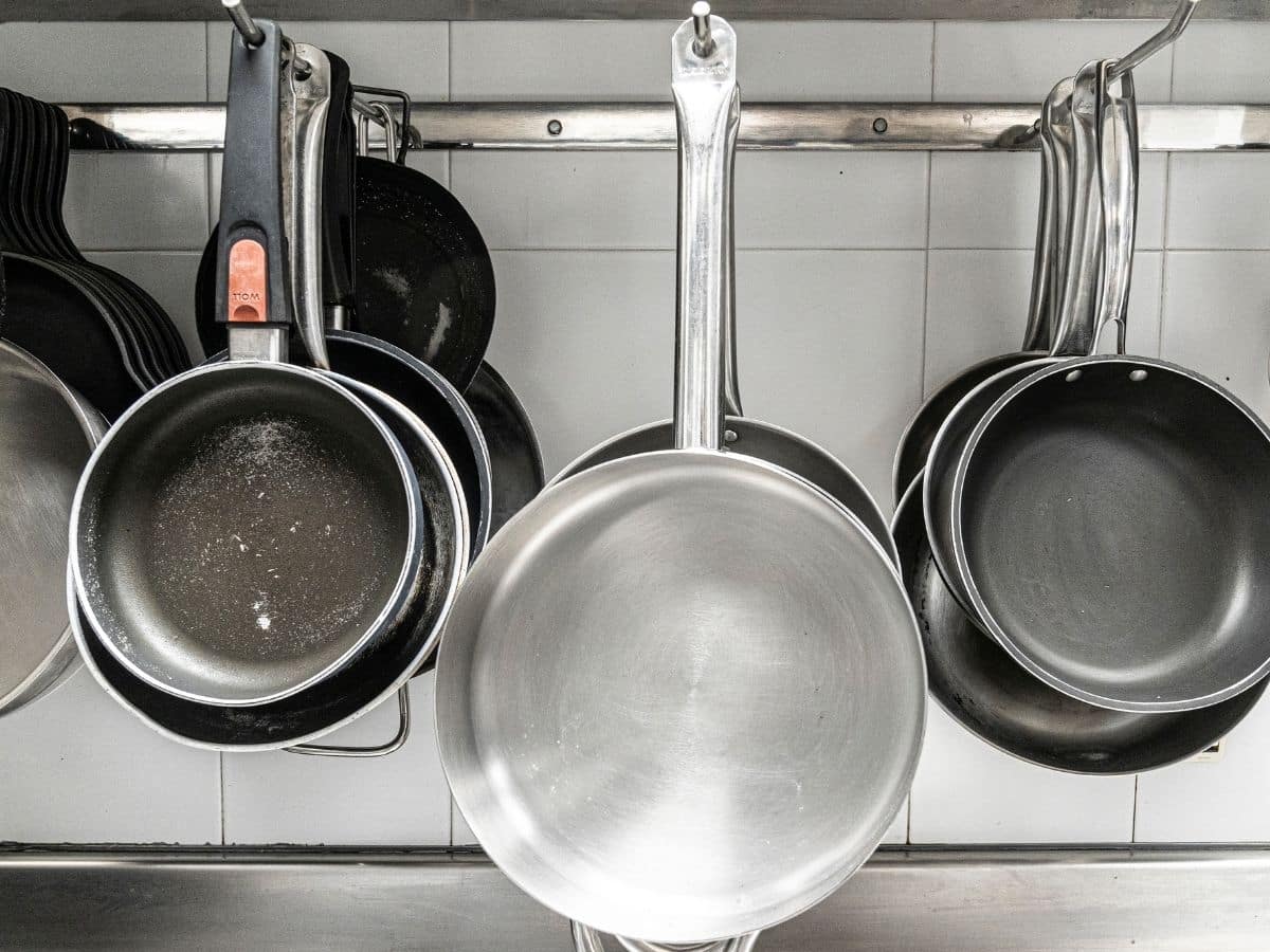 variety of skillets hanging in a kitchen.