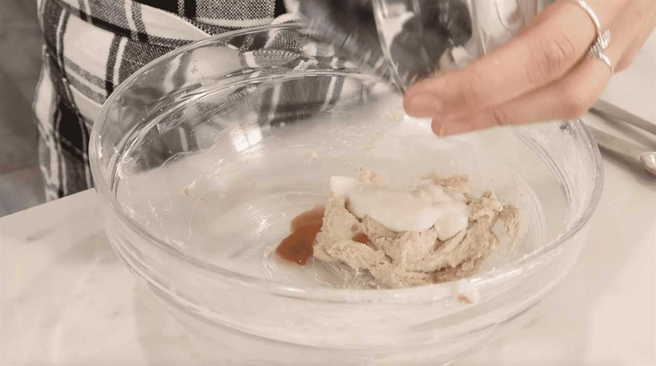 vegan yogurt being added to cookie dough in a mixing bowl