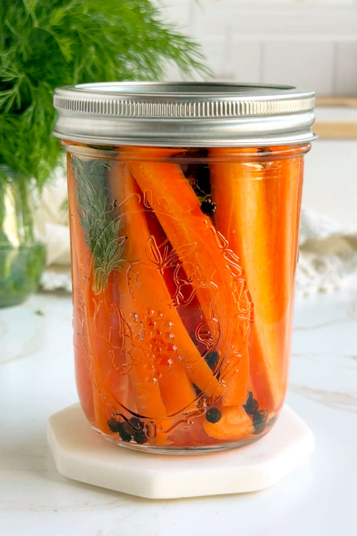 The pickled carrots in a sealed glass jar after adding the pickling brine.