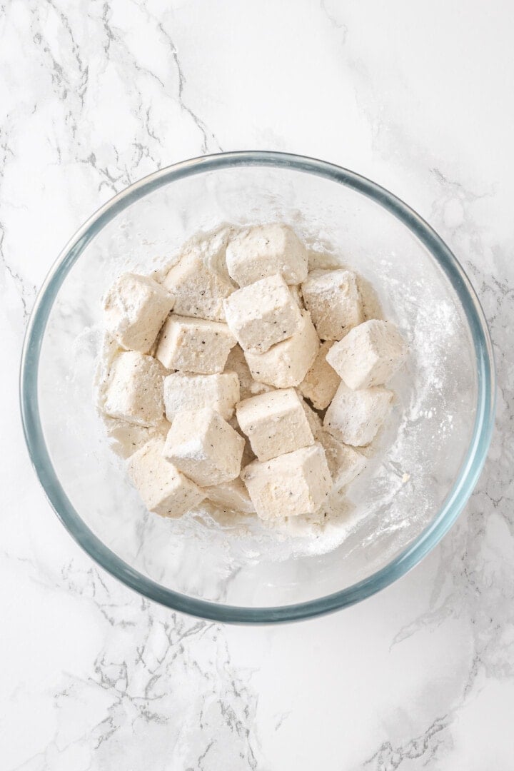 Overhead view of tofu cubes in cornstarch mixture