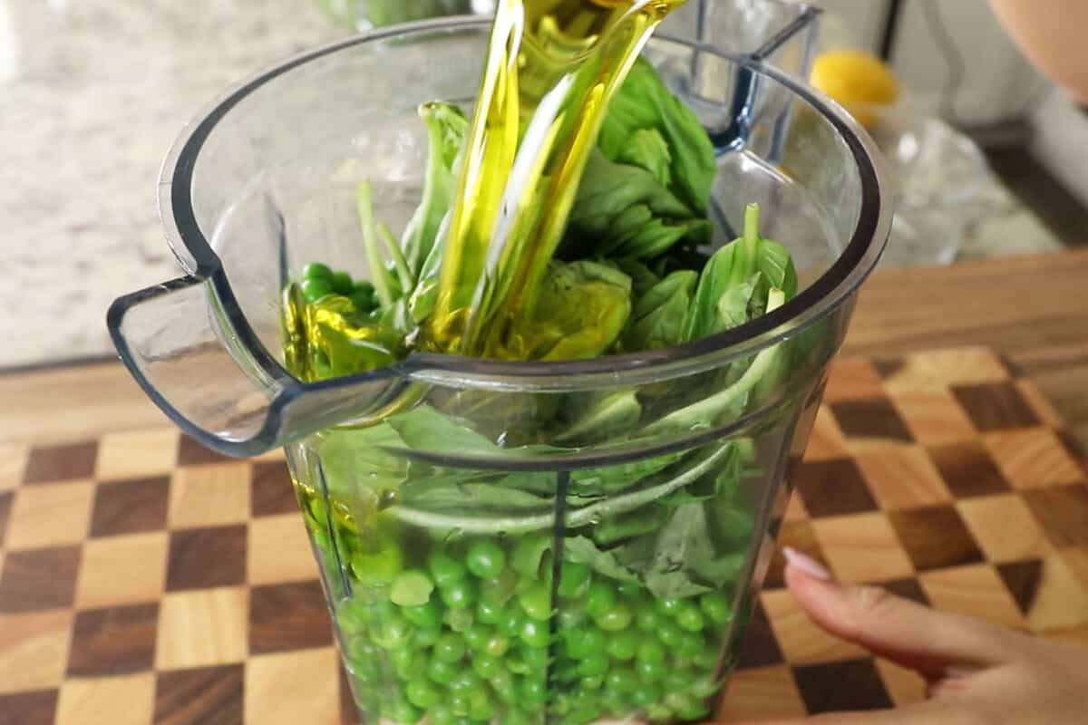 step by step olive oil being added into a blender