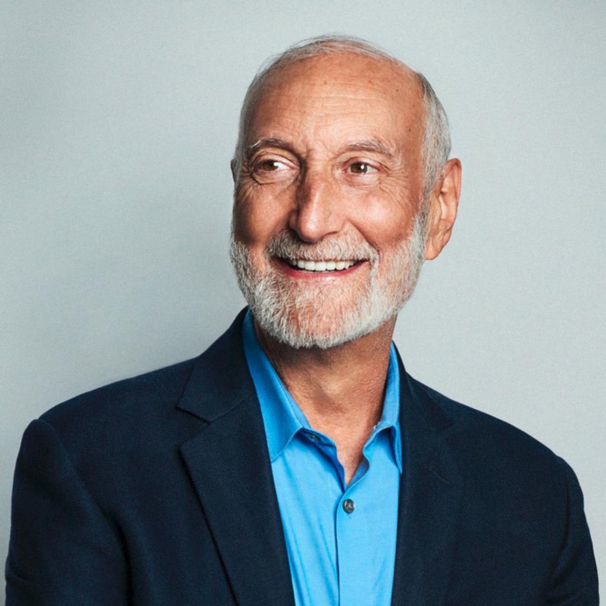 Headshot photo of vegan doctor Dr. Michael Klaper in a suit and blue shirt. 
