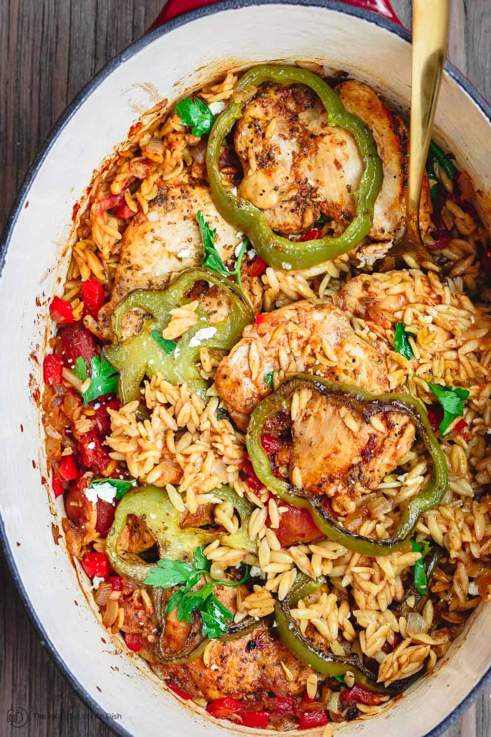 Greek Baked Chicken Orzo Recipe | The Mediterranean Dish. This is the perfect weeknight dinner! One-pot Greek chicken with orzo, onions, bell peppers, and tomato. And loads of Greek flavors. From themediterraneandish.com #greekfood #mediterraneanfood #mediterraneandiet #chickendinner #chickenrecipe #healthyrecipe #onepotdinner #easydinner