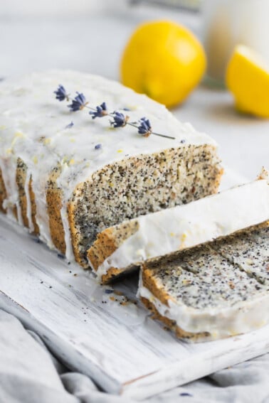 Gluten-free vegan lemon poppyseed loaf with a glaze slices on a cutting board