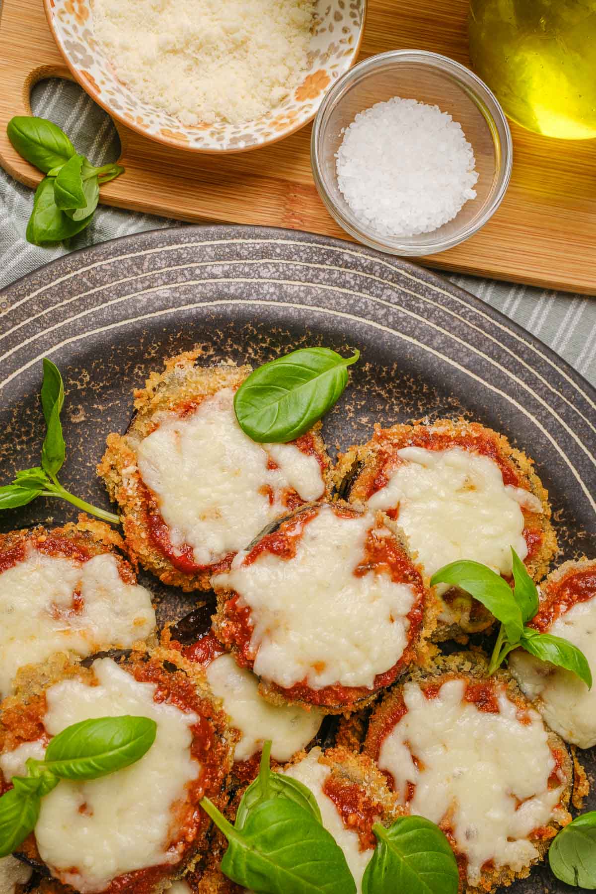 A plate of vegan eggplant parmesan with marinara sauce and vegan mozzarella.