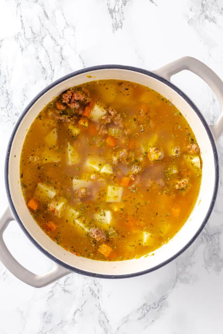 Overhead view of cheeseburger soup after adding broth