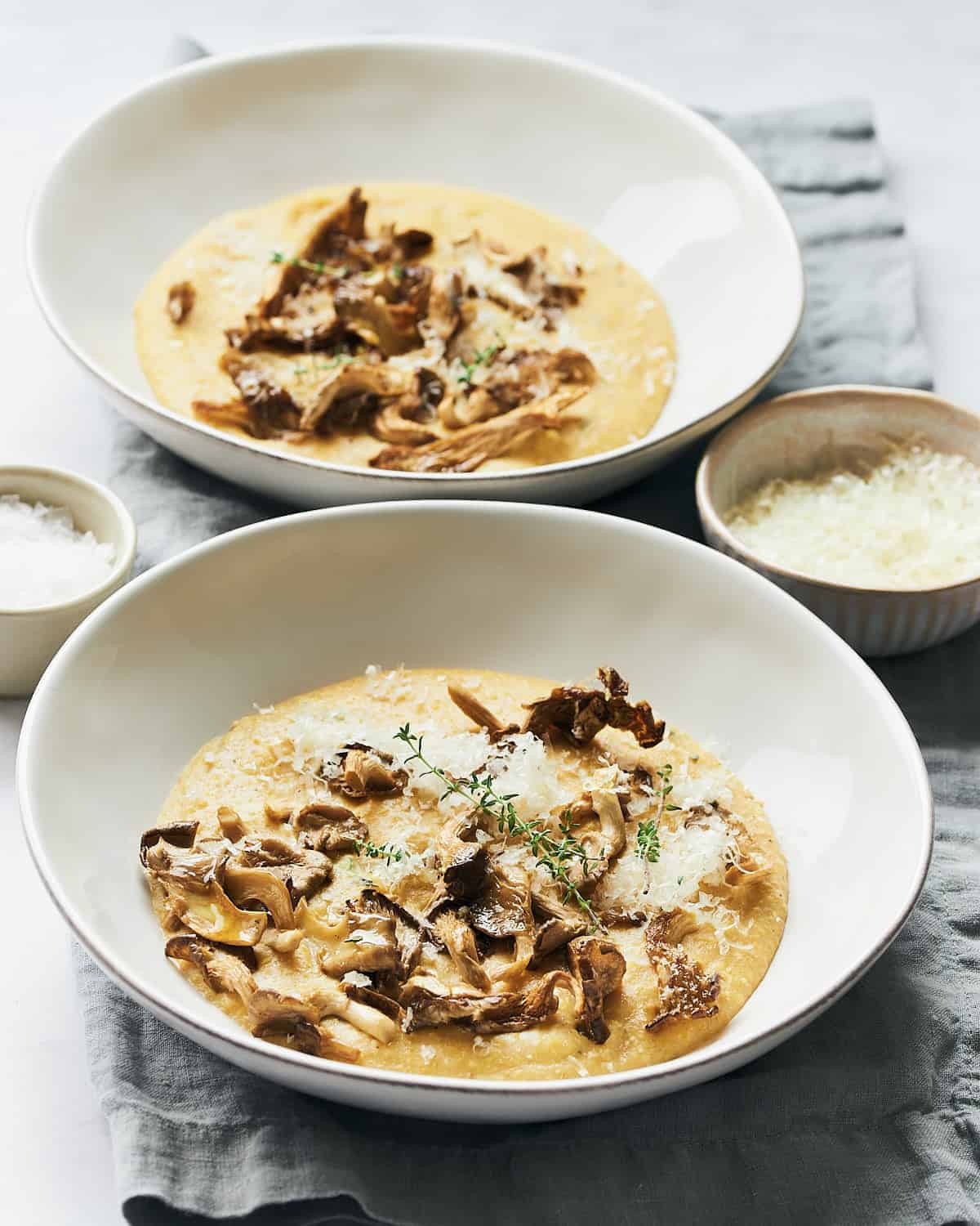 bowl of polenta with oyster mushrooms and herb garnish