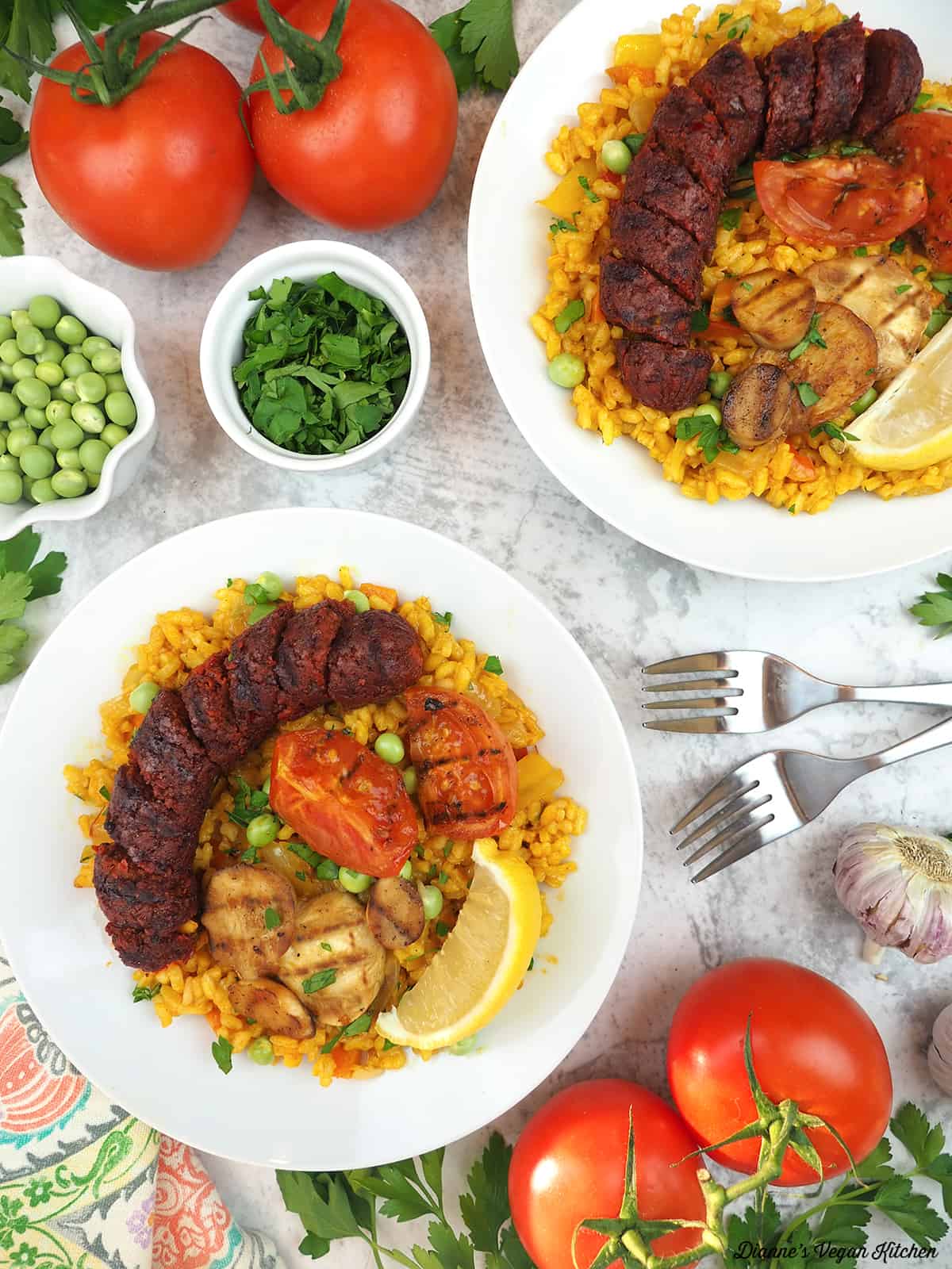 Two paella bowls with vegan sausage and oyster mushroom scallops.