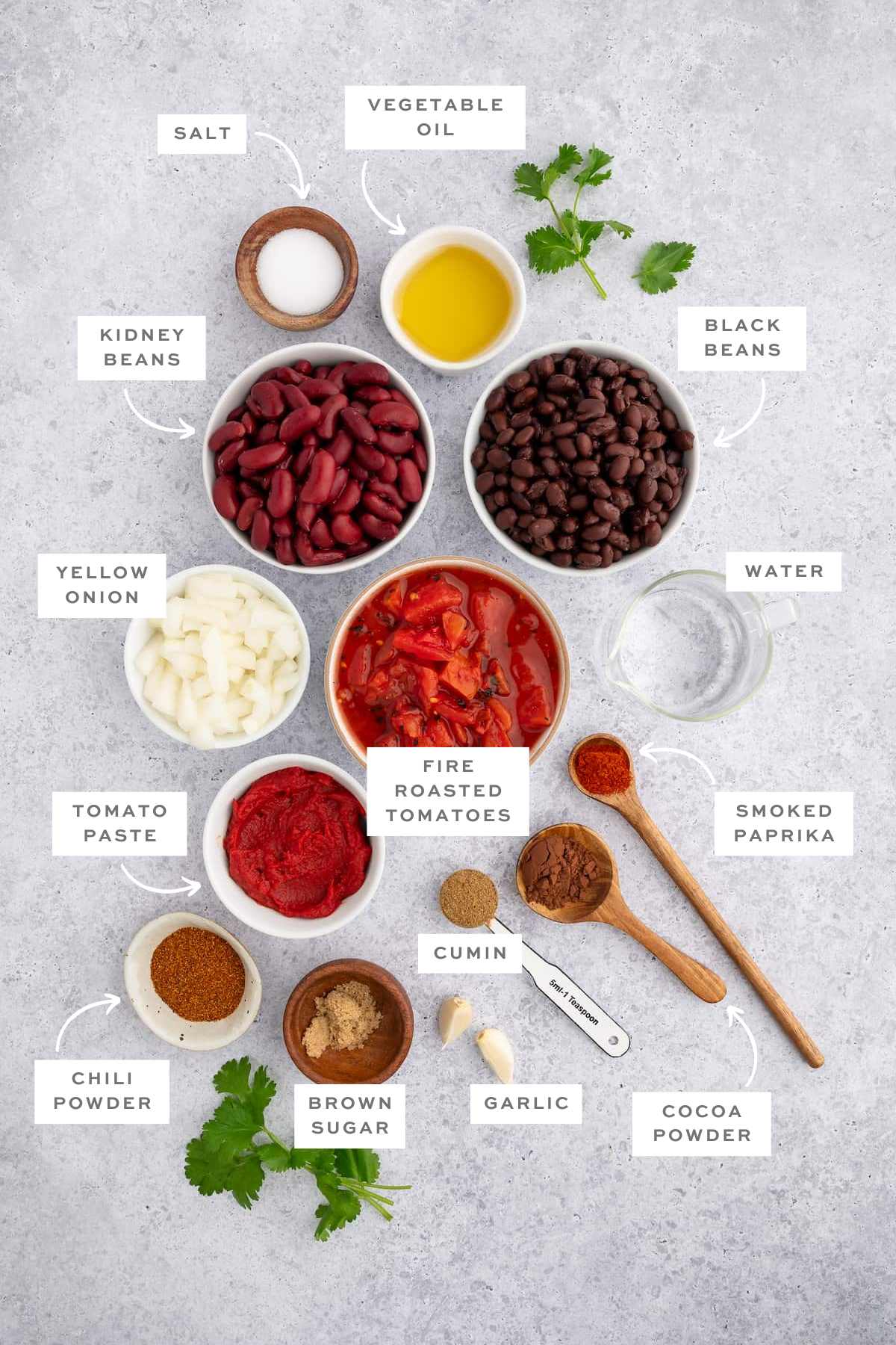 Gathered ingredients for this vegan chili recipe in various bowls with labels.