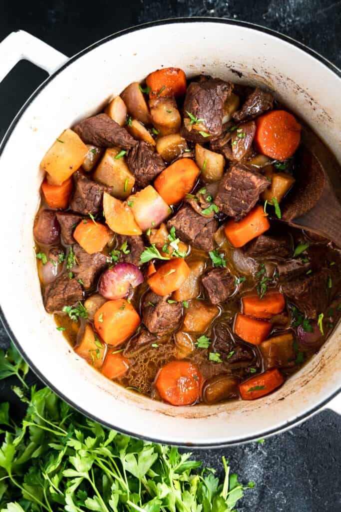 Keto Beef Stew in a cast iron Dutch oven on a black background