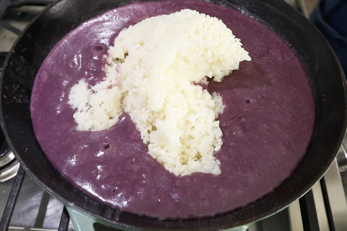 adding rice to ube mixture in wok