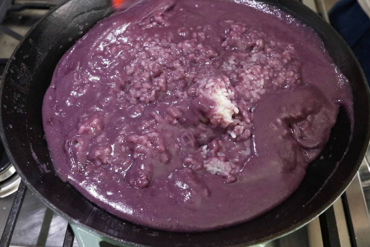 adding ube mixture to rice in wok