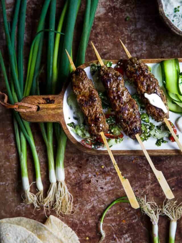 Beef Kafta Kebab with green onions in the background.