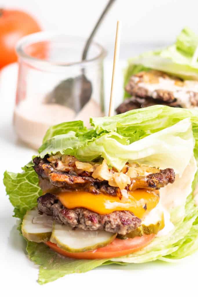 Keto Burger on a upside down sheet pan with tomatoes in the background